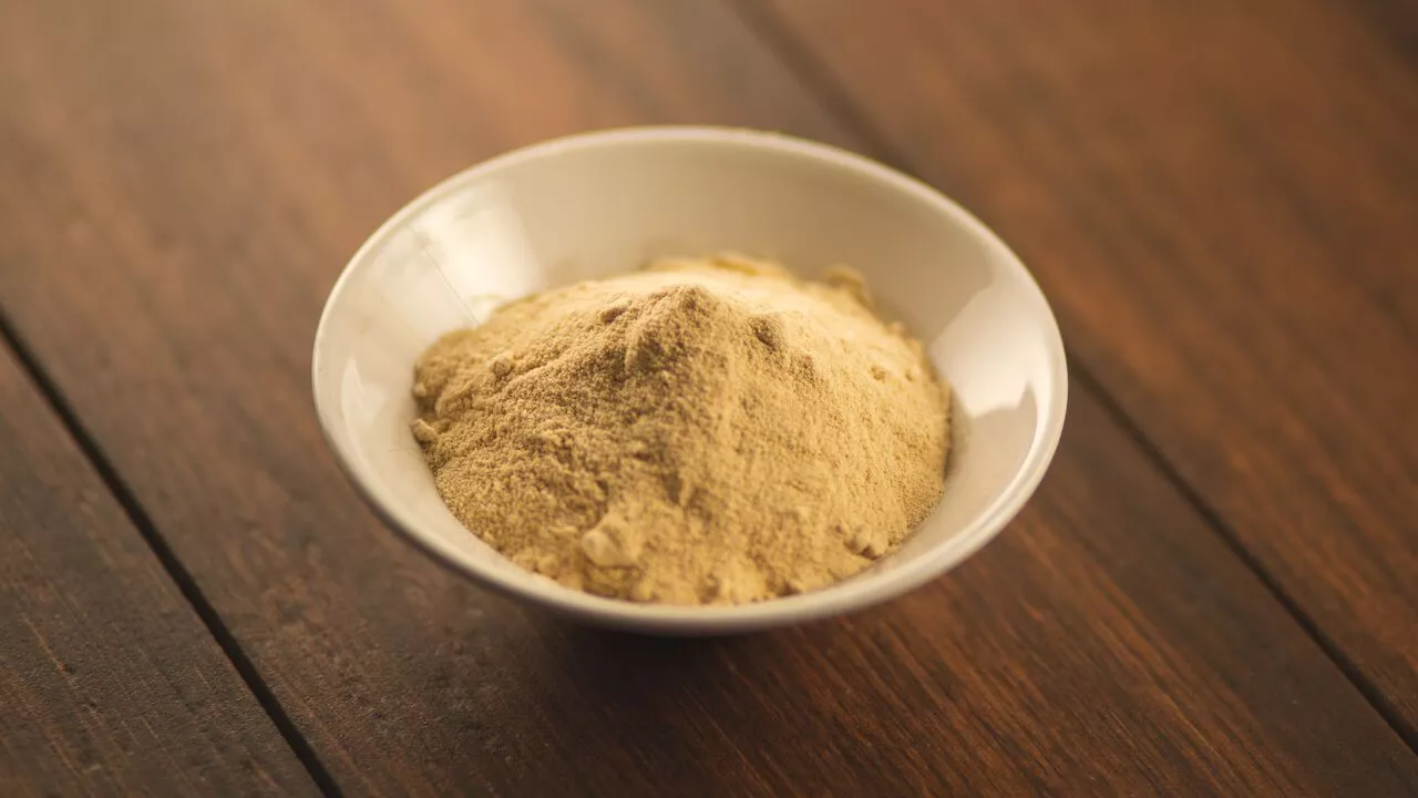 a bowl of brownulated sugar on a wooden table